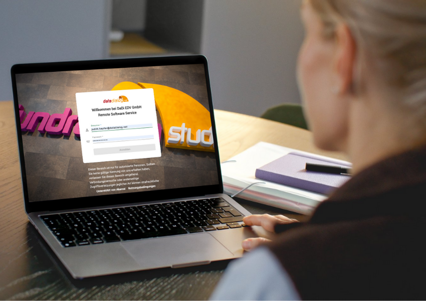 Frau sitzt vorm PC, das Login-Fenster zum Fundraising Studio wird am Bildschirm angezeigt