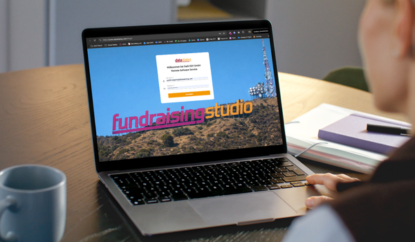 Person sitzt vor Laptop, der die Login-Seite zum Fundraising Studio zeigt